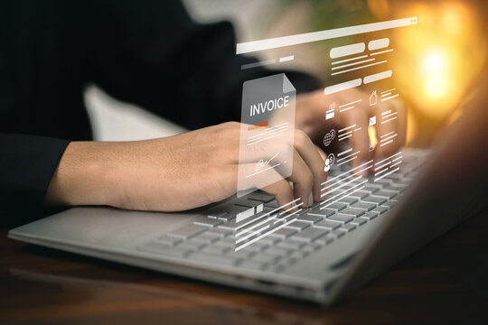 A person types on a laptop while interacting with a digital invoice on a holographic interface, representing online billing.
