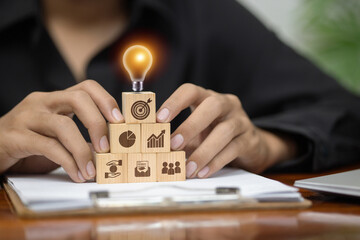 Creative business strategy and ideas concept with pyramid wooden blocks and glowing bulb