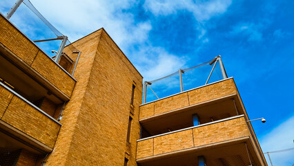 Urban facade texture with brick parking layers and blue sky as abstract background