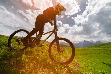 Male athlete cyclist in helmet and protective mask outdoors. MTB rider in mountainous terrain...