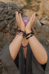 Close-up of female hands holding natural healing stones. Tools for energy balance, emotional...