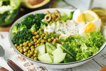 A bowl with a salad made of green vegetables	