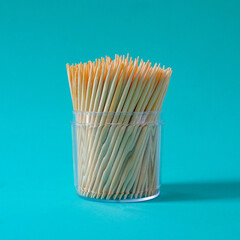 Group of toothpicks made of bamboo in a cup on background.