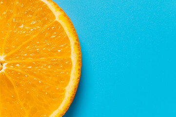 Yellow orange slice on blue background. Orange fruit close-up. Banner concept for advertising