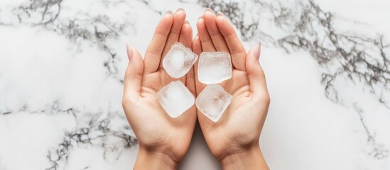 Hands Holding Ice Cubes: A Cool Refreshment Concept with Marble Backdrop