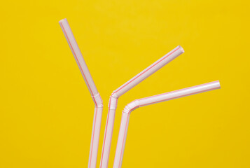 Set of plastic straws on yellow background