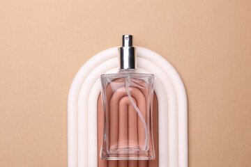 Geometric line podium with glass perfume bottle on beige background. Creative beauty showcase. Top...
