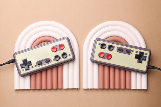 Geometric line podium with retro gamepads on beige background. - Powered by Adobe