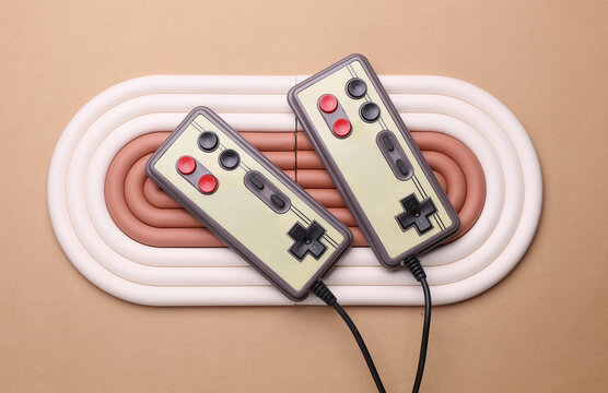 Geometric line podium with retro gamepads on beige background.