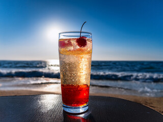 Italian soda drinks with strawberries and citrus photographed at the beach during sunset