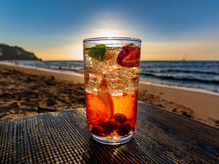 Italian soda drinks with strawberries and citrus photographed at the beach during sunset