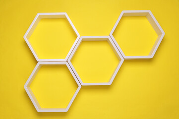 Hexagonal honeycomb wall shelves on yellow background