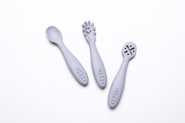 Cute silicone spoons for feeding little baby on white background