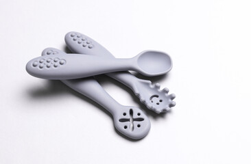 Cute silicone spoons for feeding little baby on white background