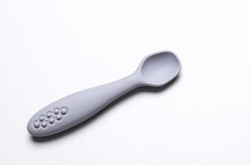 Cute silicone spoon for feeding little baby on white background