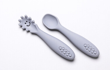 Cute silicone spoons for feeding little baby on white background