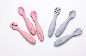 Cute silicone spoons for feeding little baby on white background