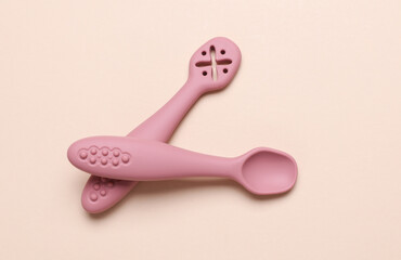 Cute silicone spoon for feeding little baby on beige background