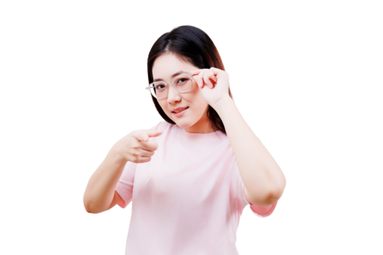 Asian young beautiful woman in a pink shirt adjusts her glasses while pointing forward with a confident expression.