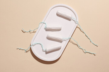 Tampons for feminine intimate hygiene in tray on a beige background. Menstruation, critical days,...