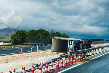 Overturned refrigerated truck in the highway median, with driver fatigue as a key contributing factor in accidents.
