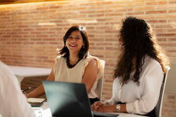 A young woman laughs during a meeting in the office in the office