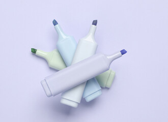 Markers or colored felt-tip pens on purple pastel background. Creative layout