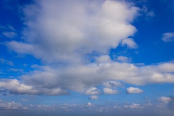 Blue Sky with Fluffy White Clouds, bright sky, summer concept, beautiful blue color, natural light, beautiful cloudscape with sunlight, blue sky.