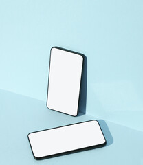 Two Smartphones on blue background with shadow. Creative layout.