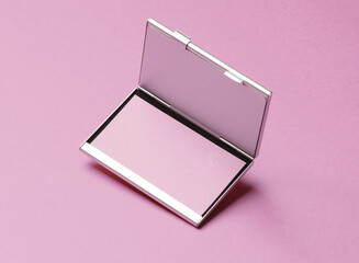 Metal box business card holder with business cards on pink background