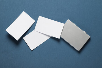 Metal box business card holder with business cards on classic blue background. Top view