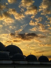 Skyward Silhouette: The majestic domes of an ancient building reach towards a vibrant, sun-kissed...