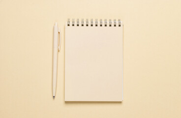 Yellow notebook with a pen on yellow background