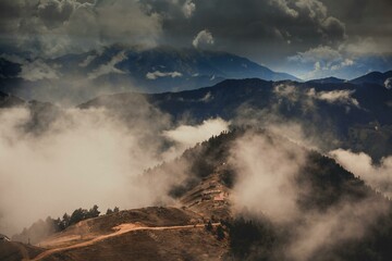 Cloudscape Over Mountain : A scenic vista of majestic mountains shrouded in ethereal clouds,...
