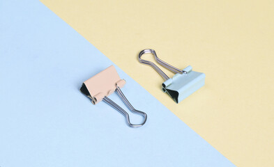 Paper clip holders on a yellow blue pastel background. Minimalism. Creative layout