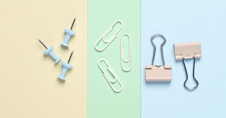 Paper clip holders and pins on a pastel background. Minimalism. Creative layout