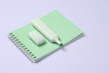 Notebook with a marker on a purple background.
