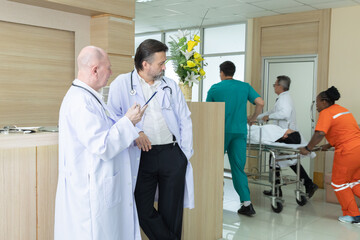 Obraz premium Hospital, healthcare, medical, doctor, nurse team stands discussing patient case with clipboard in hand, exchanging supervision, expertise, and instructions in clinical hallway, multiethnic specialist