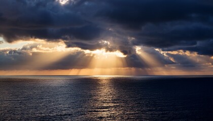 majestic sun rays breaking through dark clouds over the ocean at dusk