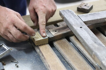 Carpenter making a table from recycled wood with a hinge