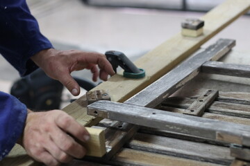 Carpenter making a table from recycled wood with a hinge