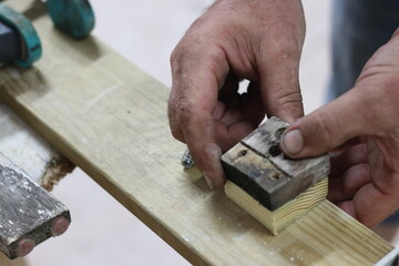 Carpenter making a table from recycled wood with a hinge