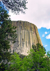 Basalt columns rise sharply from pine-dotted slopes at Devils Tower in Wyoming. Captured on a...