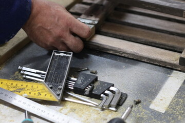Carpenter making a table from recycled wood with a hinge