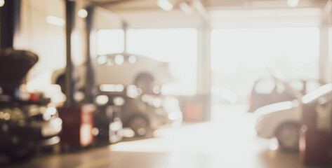 Blurred view of cars in a garage with a vehicle on a lift.