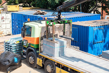 Delivery lorry HIAB with mobile crane and Brick Block Grab Lifting Attachment unloading and moving...