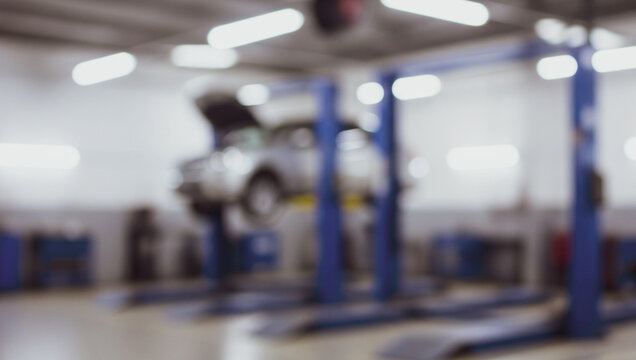 Car on lift in auto repair shop blurred background with tools and equipment. - Powered by Adobe