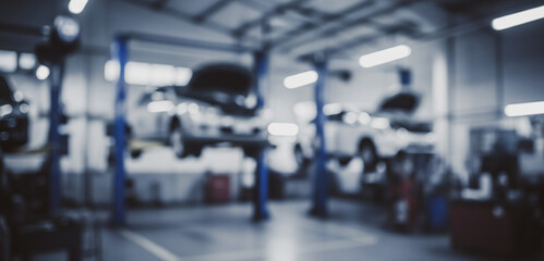Cars on lifts being repaired in a garage with mechanics working.