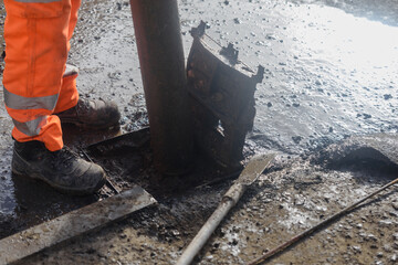 Road workers opened road gully iron top to clean it from debris and dirt to prevent street flooding