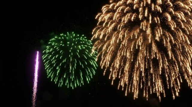 A bright red firework bursts in the dark night sky